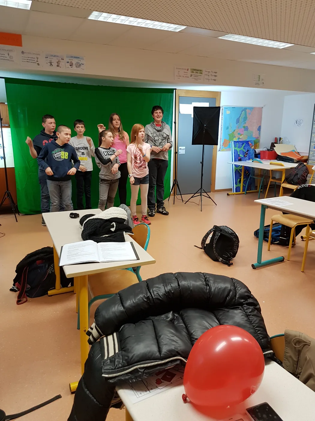 Les élèves lèvent les bras lors d’une scène tournée en salle de classe.
