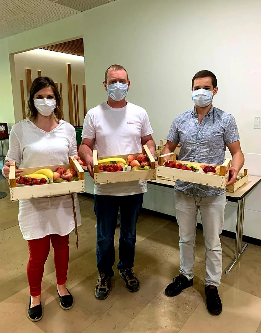 Trois personnes remettent des paniers de fruits à l’hôpital de Wissembourg.